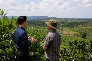 Chủ sở hữu bất động sản trao đổi với chuyên gia quản lý tài sản tại một khu đất ở Đắk Nông, thể hiện nhu cầu hỗ trợ theo dõi và vận hành từ xa.
