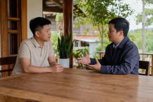 Người mua bất động sản trao đổi với chuyên gia tư vấn tại không gian văn phòng mở ở Đắk Nông, tập trung vào việc đặt câu hỏi và phân tích thông tin trước khi quyết định giao dịch.