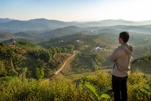 Toàn cảnh một người mua đang khảo sát khu vực bất động sản tại Đắk Nông từ điểm nhìn trên cao, quan sát sự kết nối giữa tài sản, đường tiếp cận và môi trường xung quanh trước khi đ